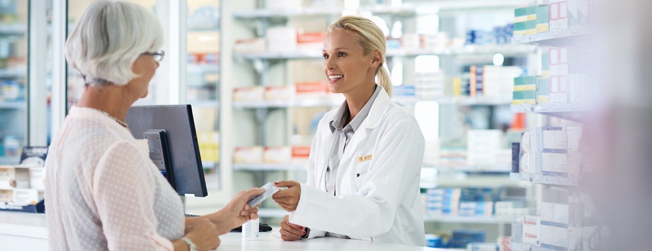 Shot of a young pharmacist helping an elderly customer